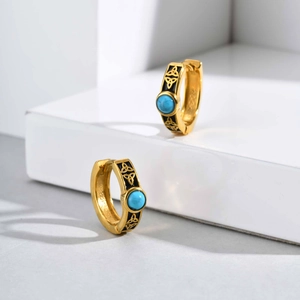 Detailed macro view of gold Celtic knot earrings with turquoise stone inlay