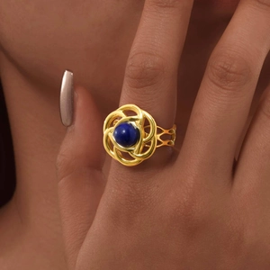 Dettaglio anello in oro 18K con petali intrecciati e pietra di lapislazzuli blu
