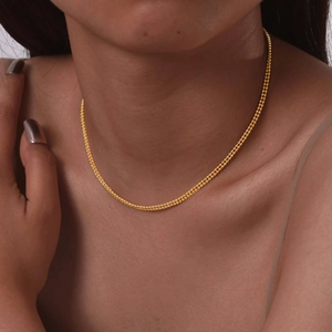 Detailed view of an 18K gold double layer bead chain necklace on a model neck