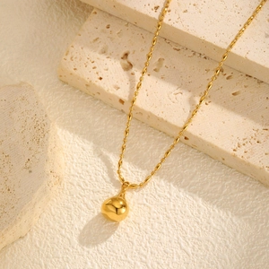 Macro dettagliata della collana a catena a grani placcata oro 18K con pendente a goccia