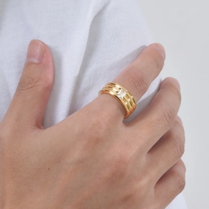 Macro view of triple-layered gold ring featuring a rectangular white zircon stone inlay