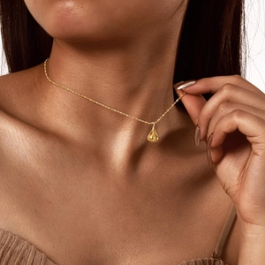 Collana minimalista in acciaio inossidabile oro 18K con ciondolo a goccia su una modella