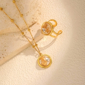 Golden ocean jewelry set featuring starfish and seashell pendants on stone texture