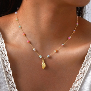 Bohemian gold ocean necklace with colorful beads and conch shell pendant on a model