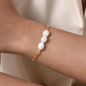 Vista macro del bracciale placcato oro 18K con tre perle barocche su una catena sottile