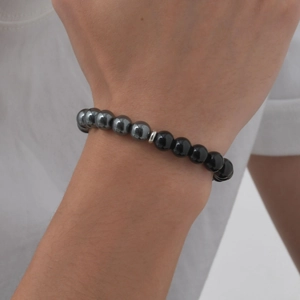 Detail of beaded bracelet with tiger eye stone and obsidian beads on male wrist