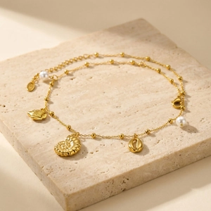 Collier doré thème océan avec pendentifs coquillages et perles blanches pour look de plage