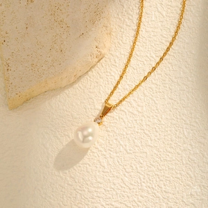 Macro shot of French vintage pearl drop necklace with gold chain and zirconia stone