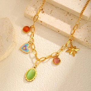 Macro detail of gold stainless steel necklace with cat eye stones and heart charms