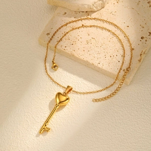 Elegante goudkleurige roestvrijstalen ketting met hol hart-sleutel hanger op steen