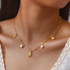Détail du collier en or 18 carats avec pendentifs étoile de mer, coquillage et perles