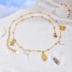Collier marin plaqué or 18 carats avec perles et étoile de mer sur sable blanc