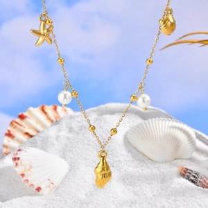 Collier d'été doré 18 carats avec pendentifs étoile de mer et perles sur sable blanc