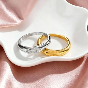 Detail of gold and silver sunburst engraved oval rings on white star ceramic tray