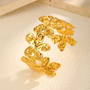 Detailed view of gold floral cuff bracelet with artistic hammered metal textures
