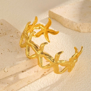 Detailed view of gold starfish cuff bracelet featuring realistic textured ocean design