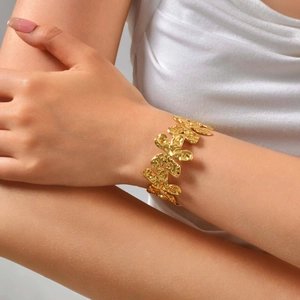 Close-up of golden irregular wrinkled starfish cuff bracelet on model wrist