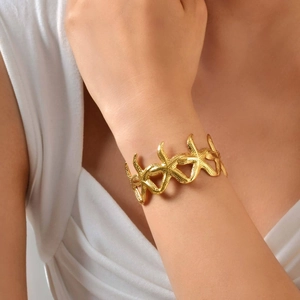 Golden starfish cuff bracelet with textured sea star design worn on a model's wrist