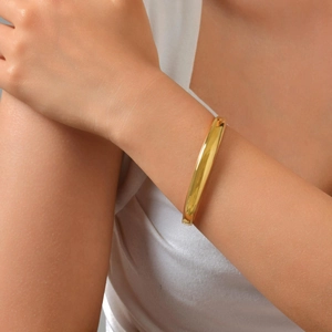 Polished 18K gold-plated stainless steel bangle with a minimalist wide rounded design