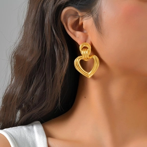 Detailansicht eines Models mit goldenen hohlen Herz-Geometrie-Ohrringen im Set