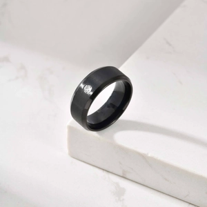 Détail d'une bague en acier inoxydable brossé noir mat ornée d'un seul diamant scintillant