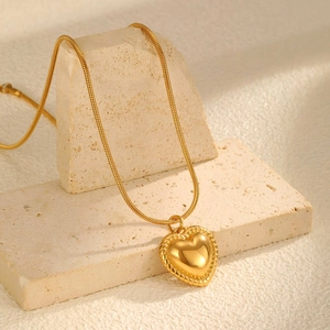 Detailansicht eines goldenen Herzanhängers mit Seilrand an einer glatten Schlangenkette