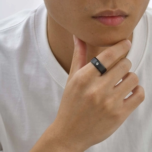 Gros plan sur une bague homme en acier inoxydable noir mat avec un petit zircon serti