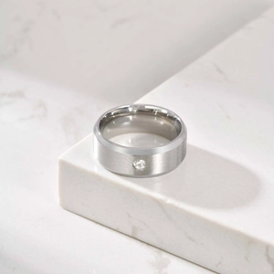 Gros plan sur la bague en acier inoxydable brossé pour hommes avec un petit diamant