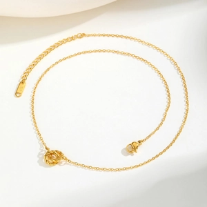 Detailed view of 18K gold intertwined triple ring pendant with lobster clasp and chain