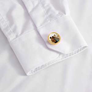 Dettaglio del gemello personalizzato in oro con foto su polsino di camicia bianca