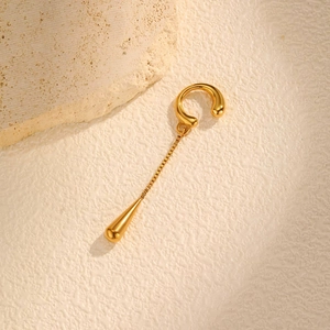Detailed view of polished gold ear cuff featuring a delicate chain and smooth teardrop pendant
