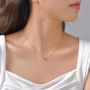 Minimalist gold double interlocking ring pendant necklace on female model collarbone