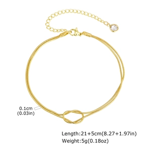 Detail of gold snake chain anklet showing knotted design and rhinestone pendant