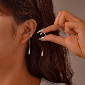Silver stainless steel ear cuff with chain and teardrop pendant shown on ear