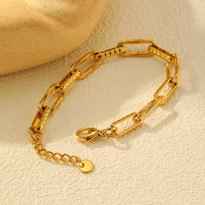 Detail of gold rectangular link bracelet with embossed diamond texture and lobster clasp