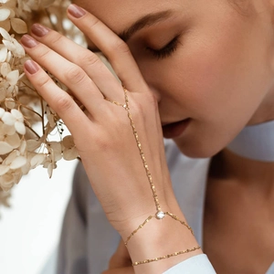 Golden stainless steel slave bracelet with zircon stone on elegant light background