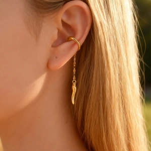 Golden stainless steel chili pendant ear cuff shown in stylish warm sunlight