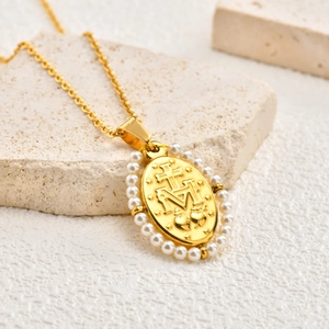 Macro detail of oval pendant with Virgin Mary symbols and pearl border on stone