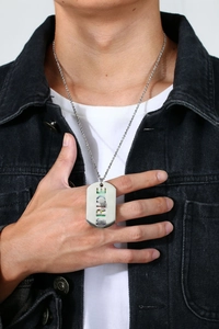 Detail of male model wearing a silver stainless steel necklace with rainbow Pride dog tag pendant