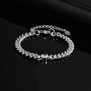Macro detail of stainless steel Cuban link bracelet with a sparkling round zircon stone