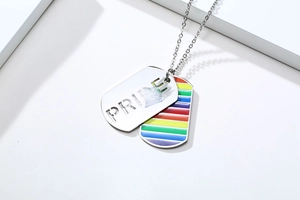 Macro shot of silver Pride necklace with rainbow stripes and cutout lettering detail