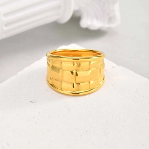 Détail macro d'une bague large plaquée or 18 carats avec motif géométrique tissé texturé