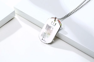 Detail of silver stainless steel dog tag necklace with colorful side edges on white block