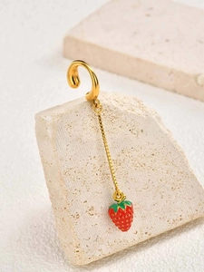 Detail shot of a long tassel clip-on earring featuring a red strawberry and golden chain