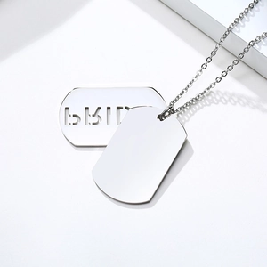 Close-up of dual silver stainless steel pendant necklace with minimalist cutout letters
