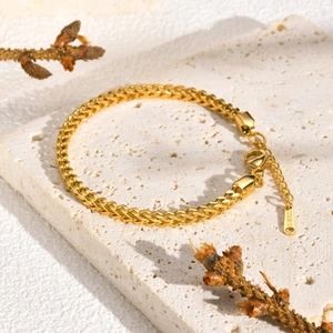 Detailed close-up of golden wheat link stainless steel bracelet with lobster clasp