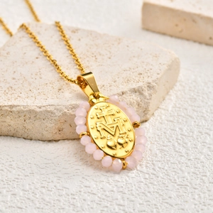 Golden oval Virgin Mary pendant necklace with pink beads and emerald zircon accents
