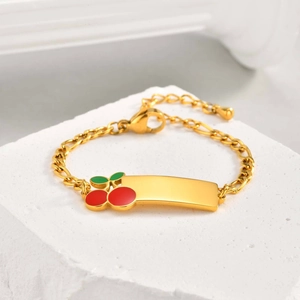 Detailed view of kids gold bracelet featuring cherry charm and engravable polished plaque