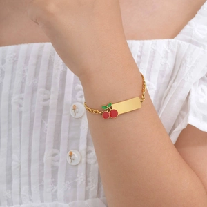 Personalized gold child bracelet with cherry charm and engravable rectangular bar plate