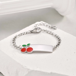 Macro detail of silver ID bracelet for kids with red cherry charm and lobster clasp